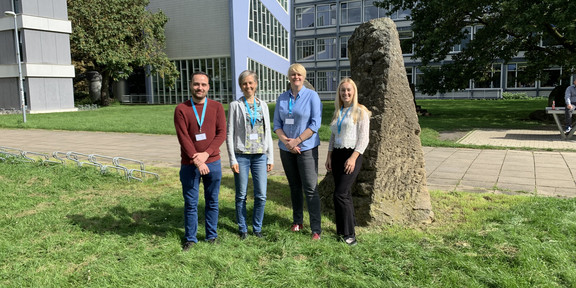 Zu sehen sind Dr. Tomke Gerdes, Junior-Professorin Dr. Lena Hünefeld und Christoph Burzlaff, die draußen vor einem Gebäudekomplex stehen.