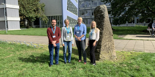 Zu sehen sind Dr. Tomke Gerdes, Junior-Professorin Dr. Lena Hünefeld und Christoph Burzlaff, die draußen vor einem Gebäudekomplex stehen.