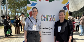 Zu sehen sind Jana-Sophie Effert und Frauke Mörike vor einem Schild der CHI 26 in Barcelona