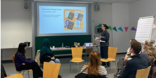 Ein Foto des Workshops mit Hannah Jones. Sie stellt dem Plenum eine Präsentation vor.