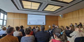 An image of an audience listening to a presentation.