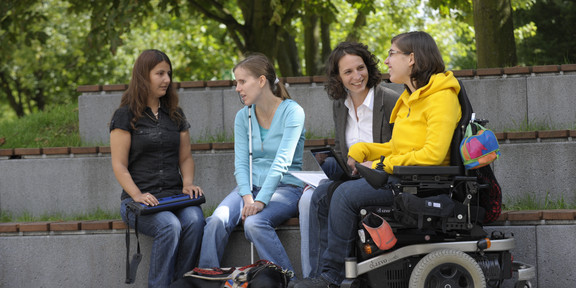Students with handicap are sitting together on campus.