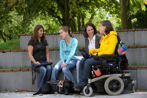 Students with handicap are sitting together on campus.